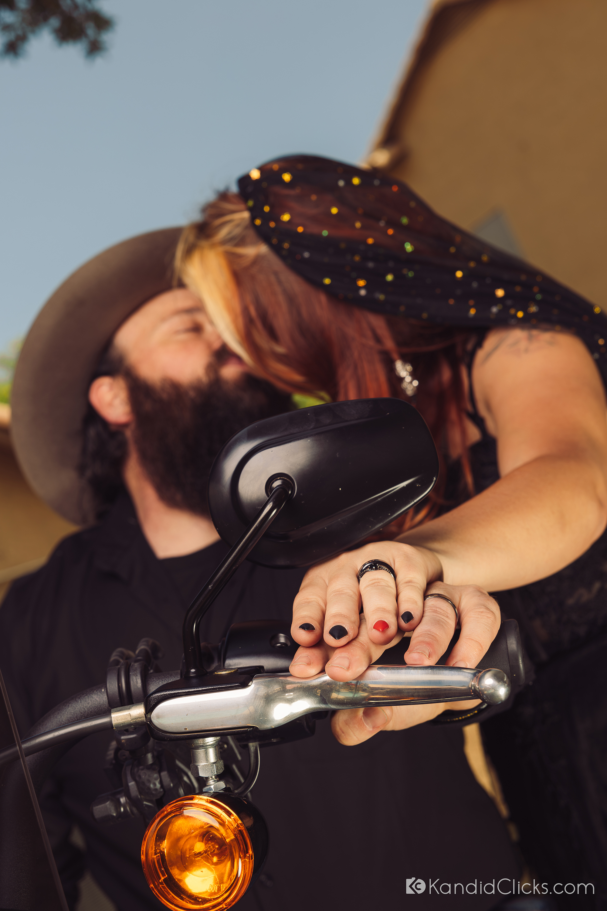 Close-up of bride and groom’s hands with rings on motorcycle handle during Arizona wedding.