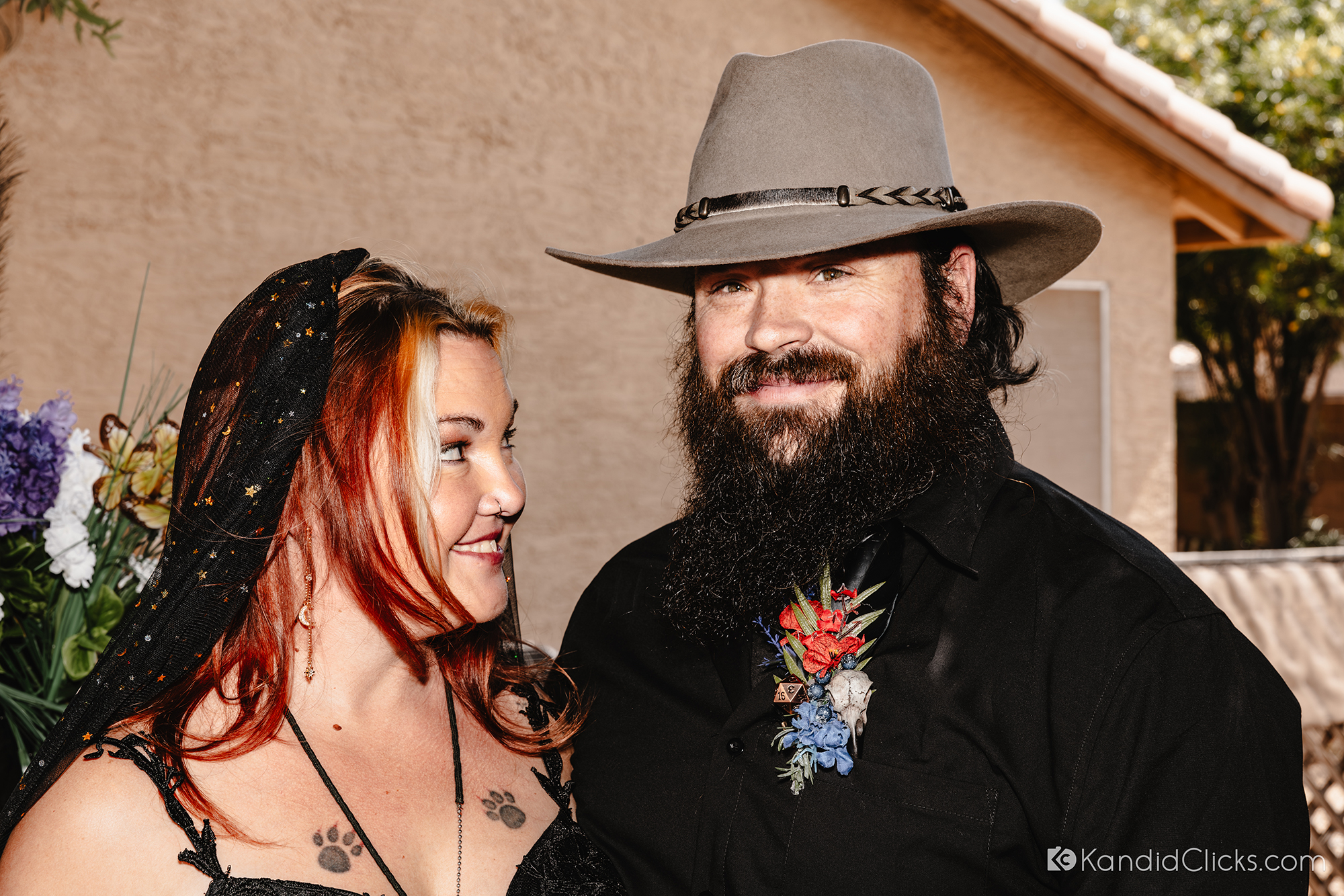 Bride and groom smiling at each other in black wedding attire.