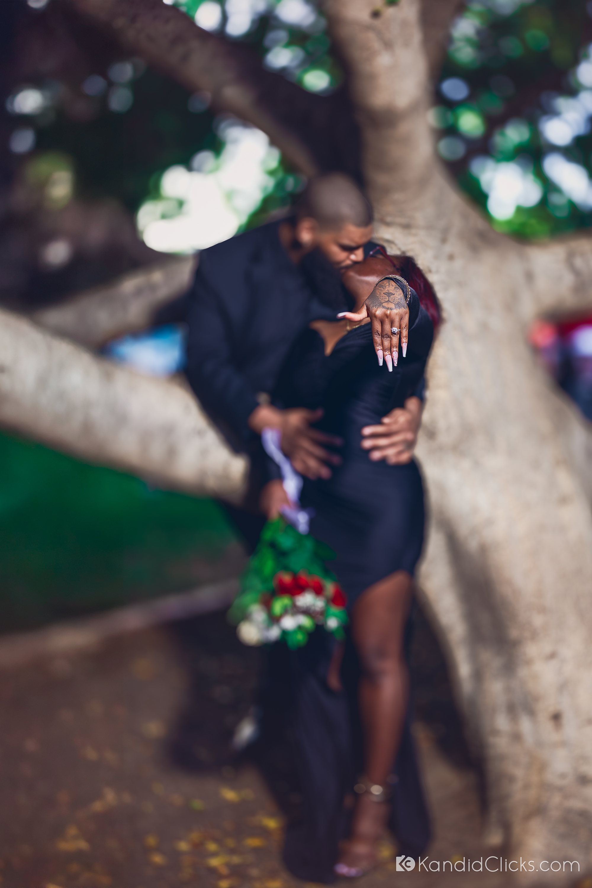 Close-up of engagement ring as a couple embraces under a tree in Arizona.