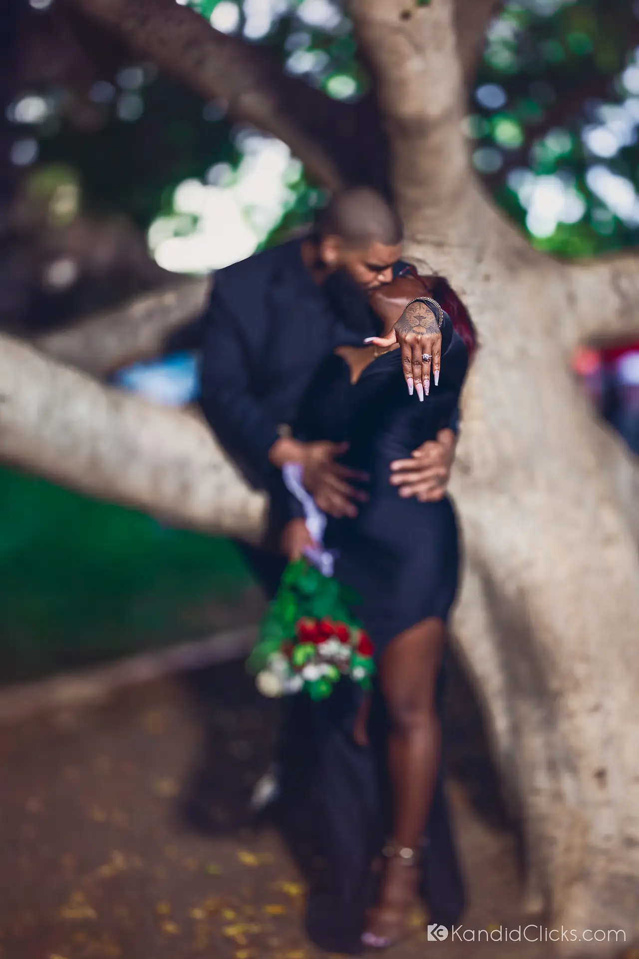 Close-up of engagement ring as a couple embraces under a tree in Arizona.