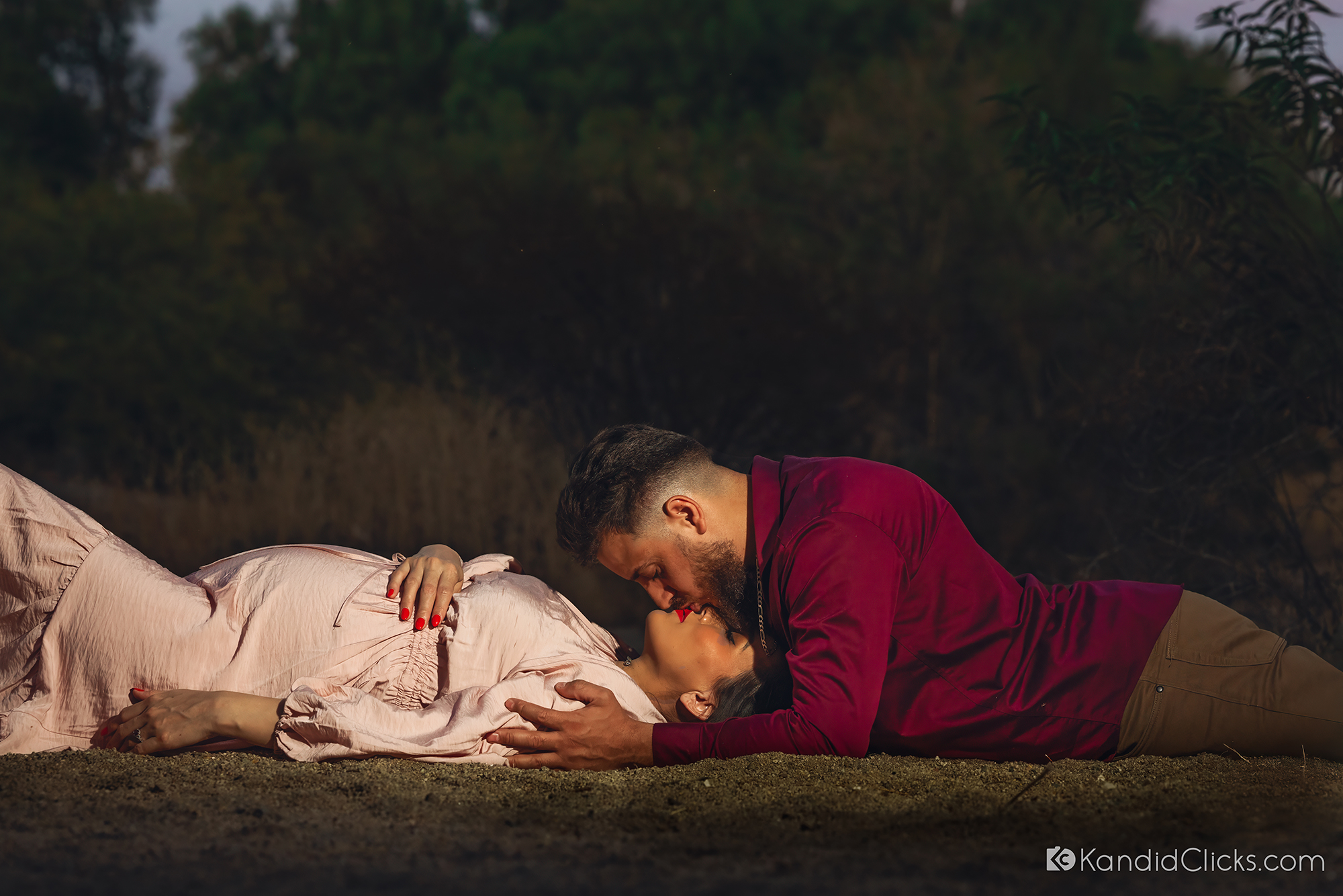 Expecting couple laying on the ground during a maternity photoshoot