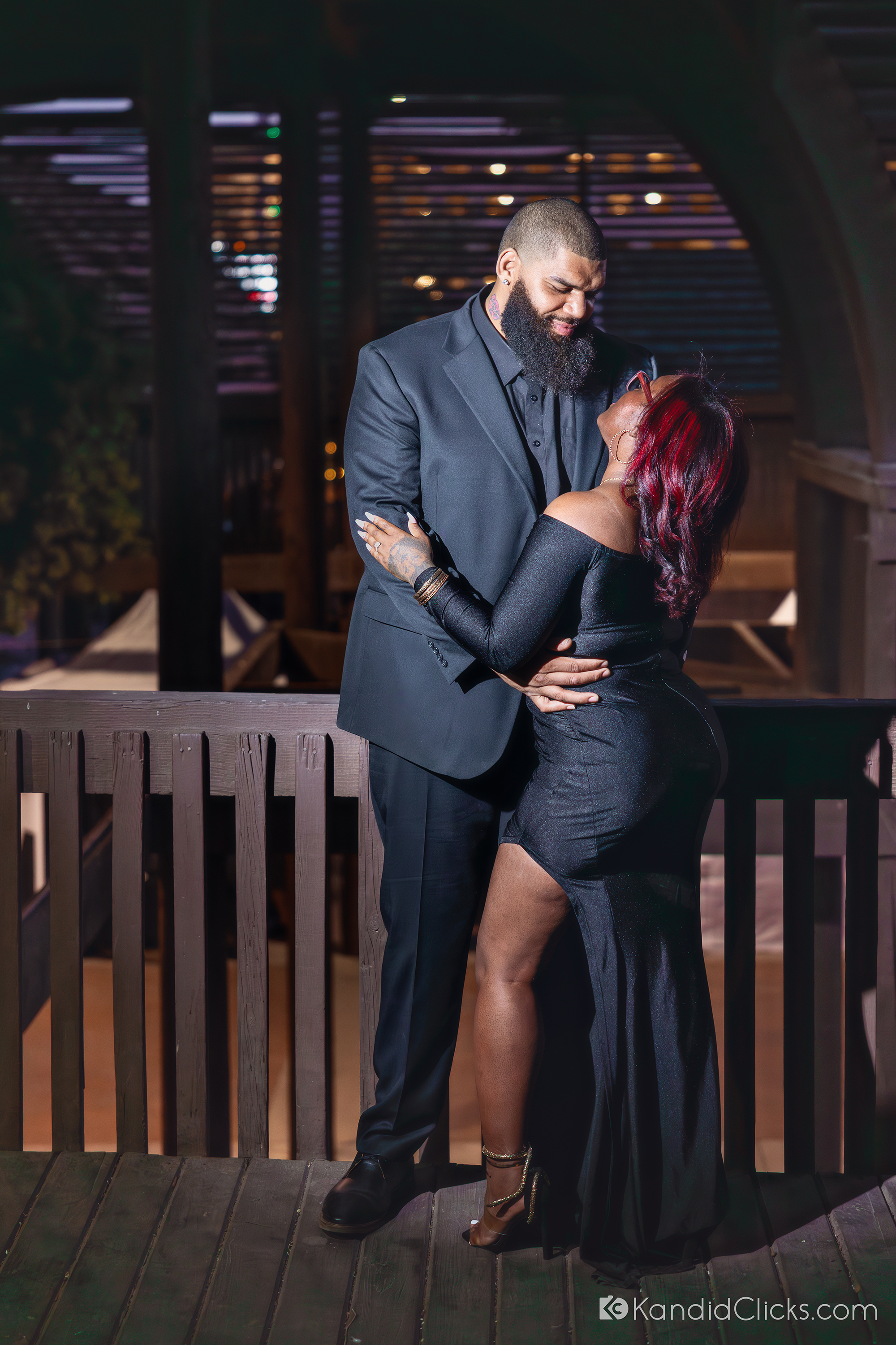 Engaged couple embracing under romantic lights in a nighttime Arizona photoshoot.