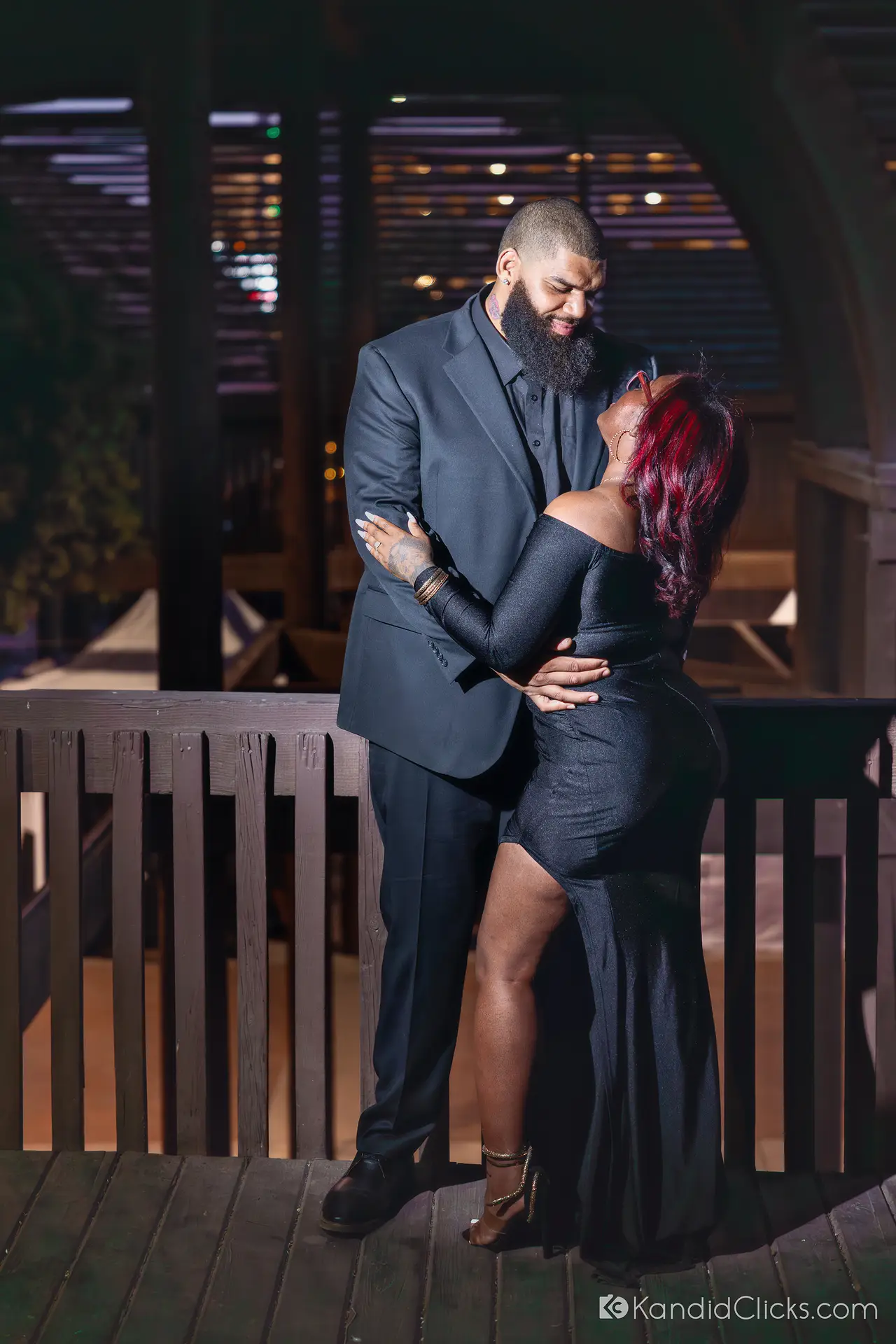 Engaged couple embracing under romantic lights in a nighttime Arizona photoshoot.
