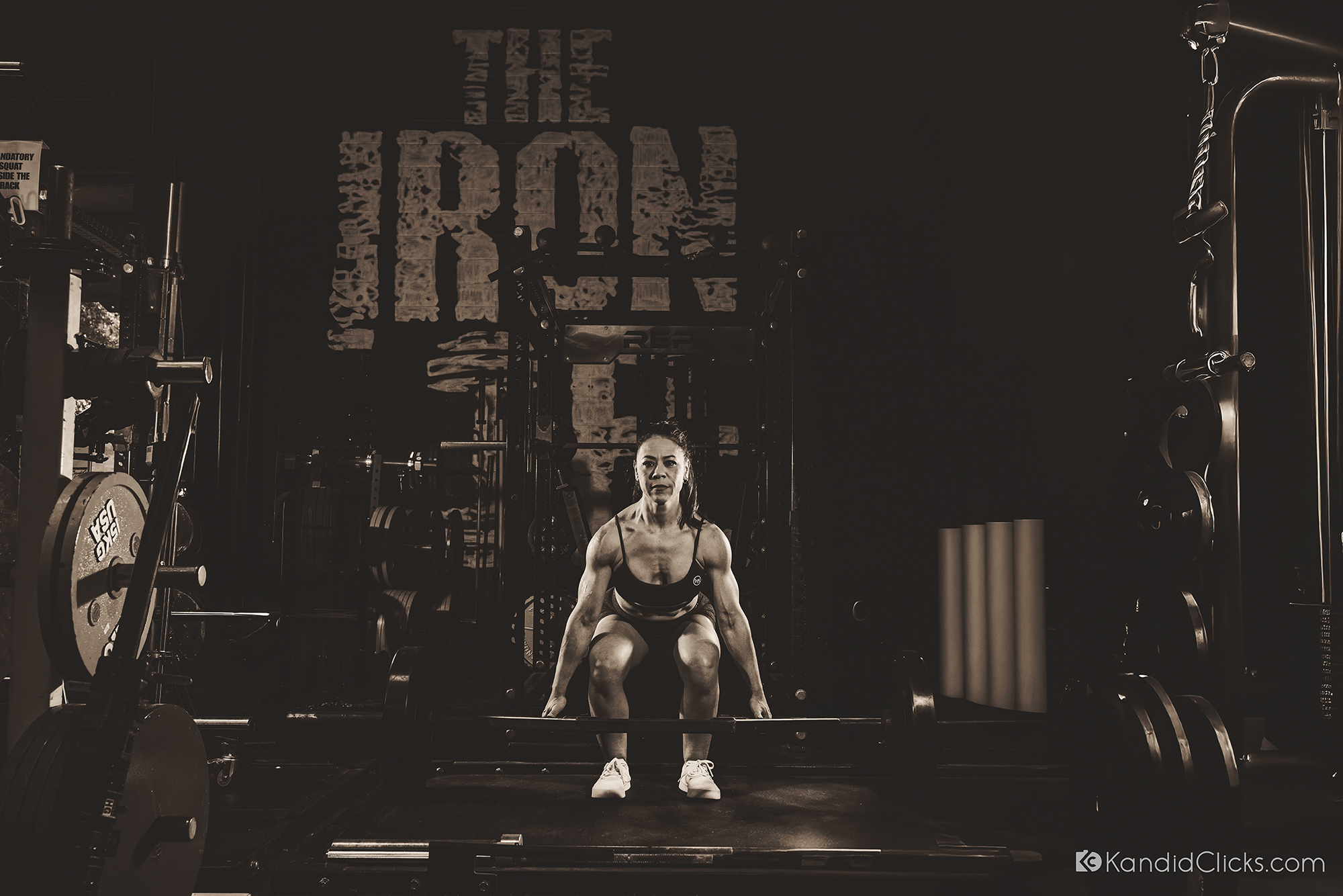 Female athlete lifting weights during strength training sports portrait session