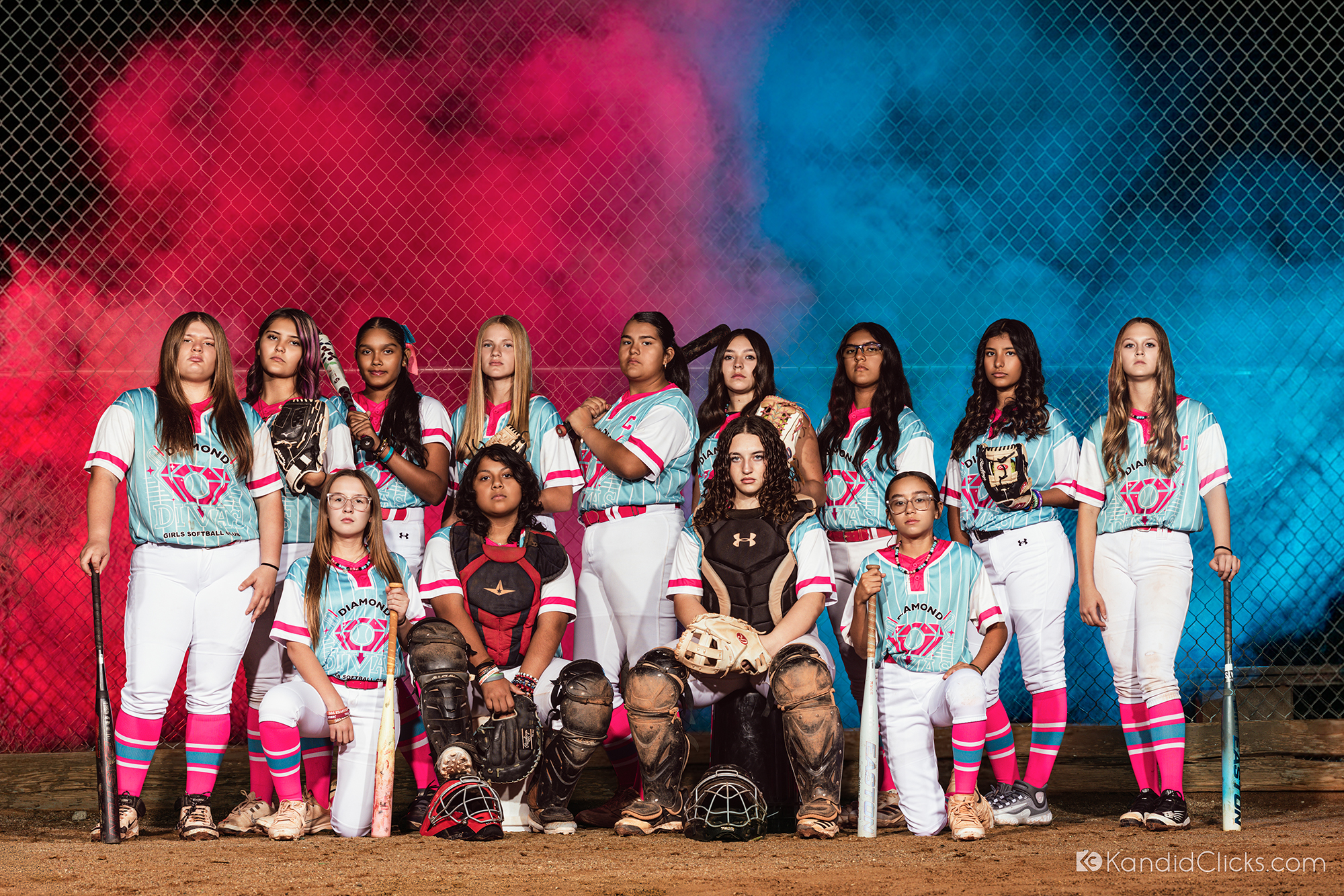 Girls softball team posing together in uniform during a dramatic studio sports photography session