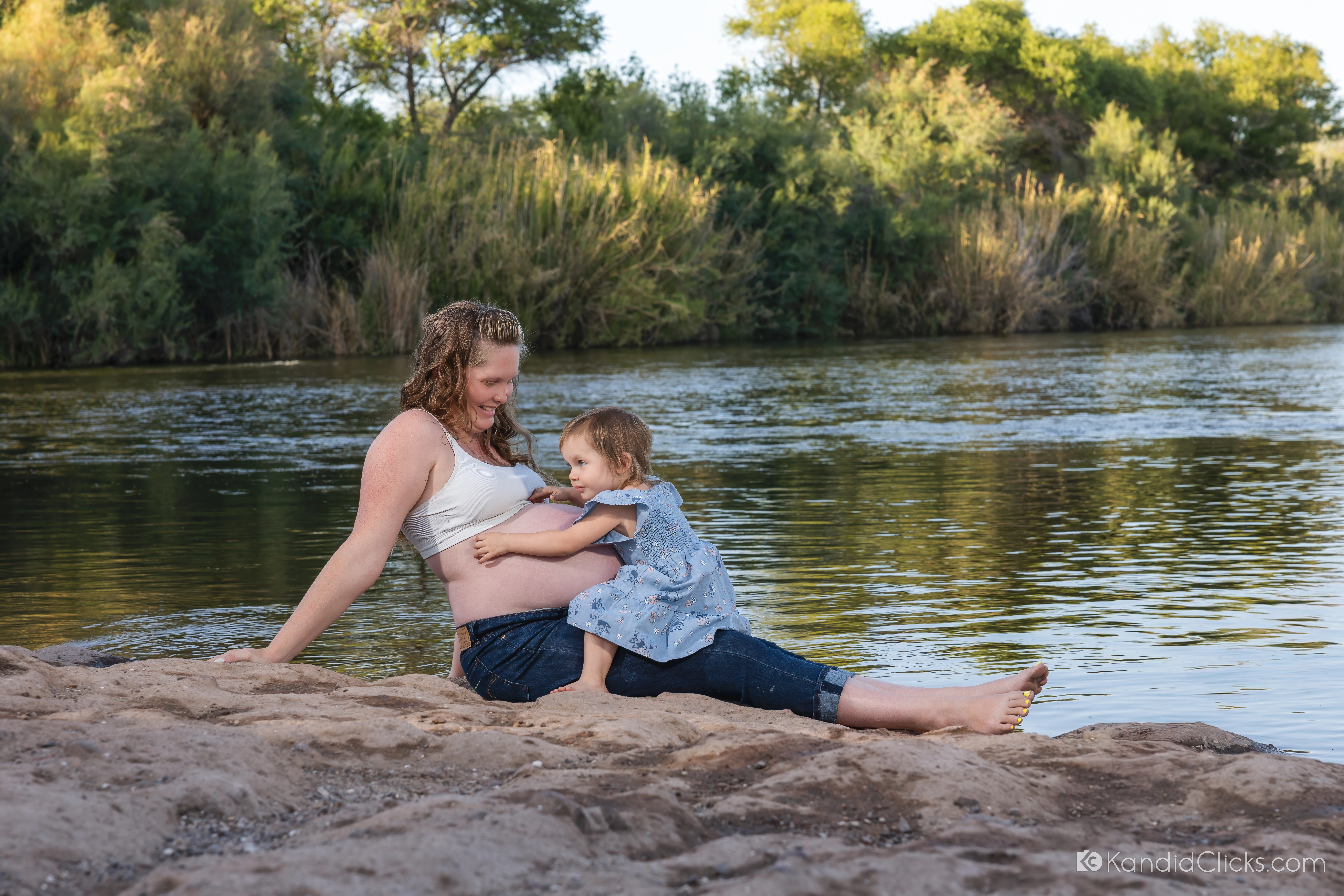 Christina cradling her bump by the Salt River at the start of her outdoor maternity session