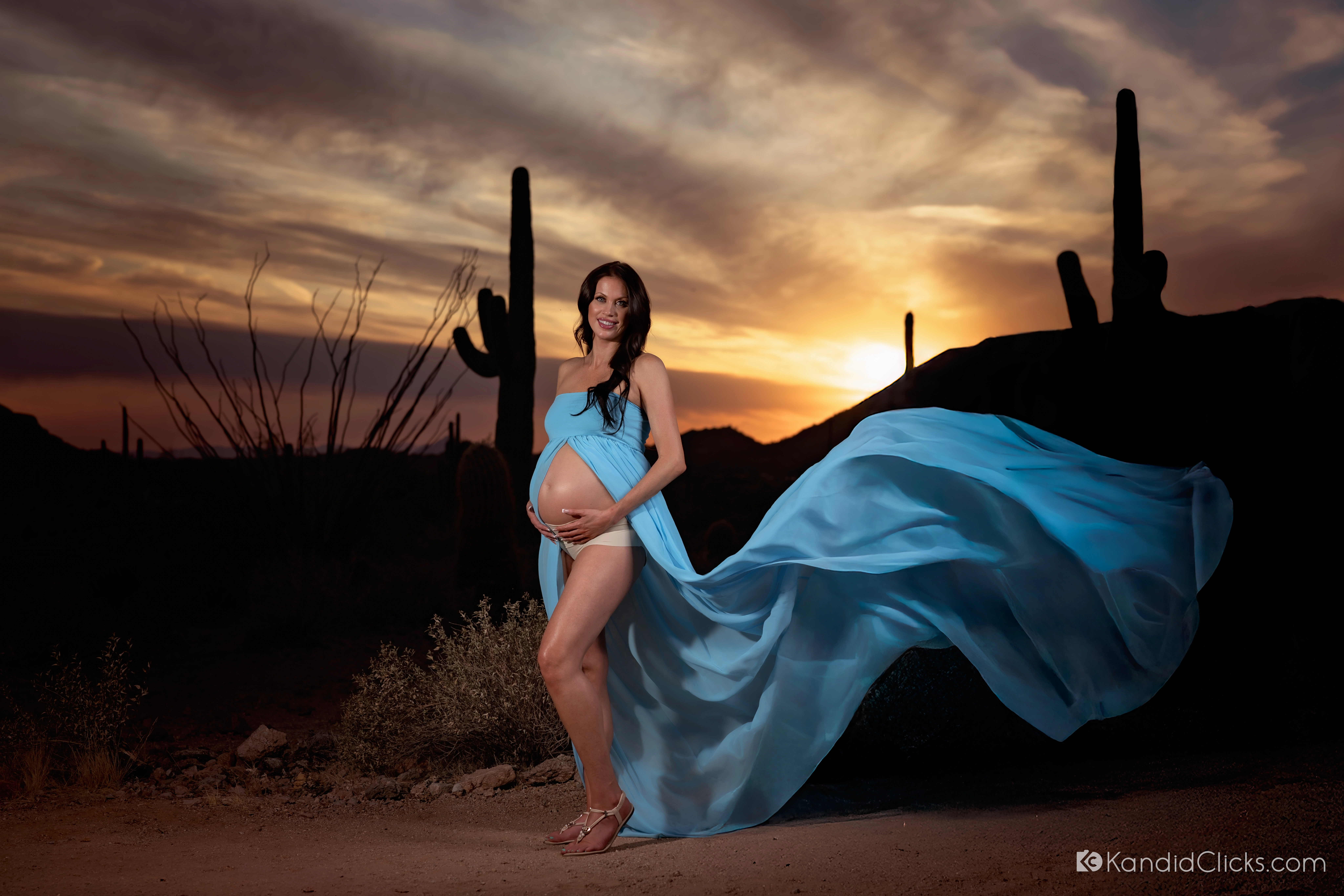 Bree's teal gown flowing in the breeze at sunset during her maternity session